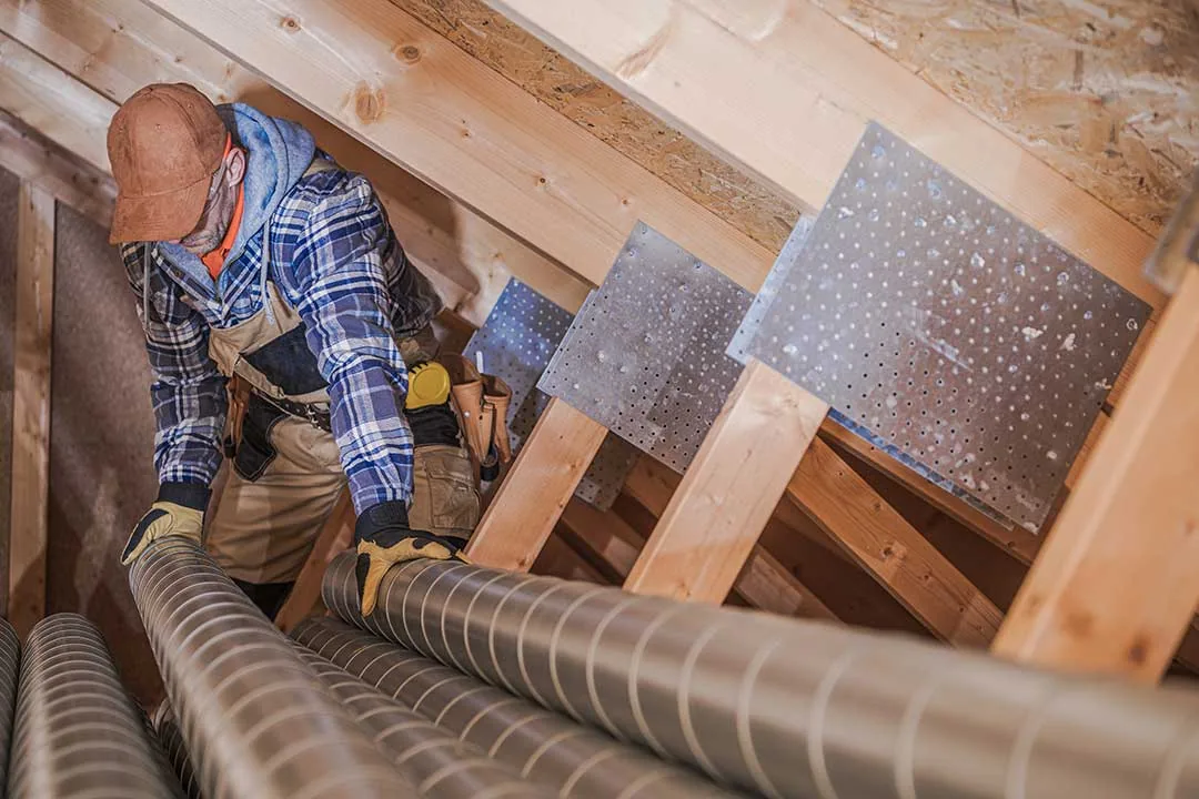 Technician assembling an air vent inside a house